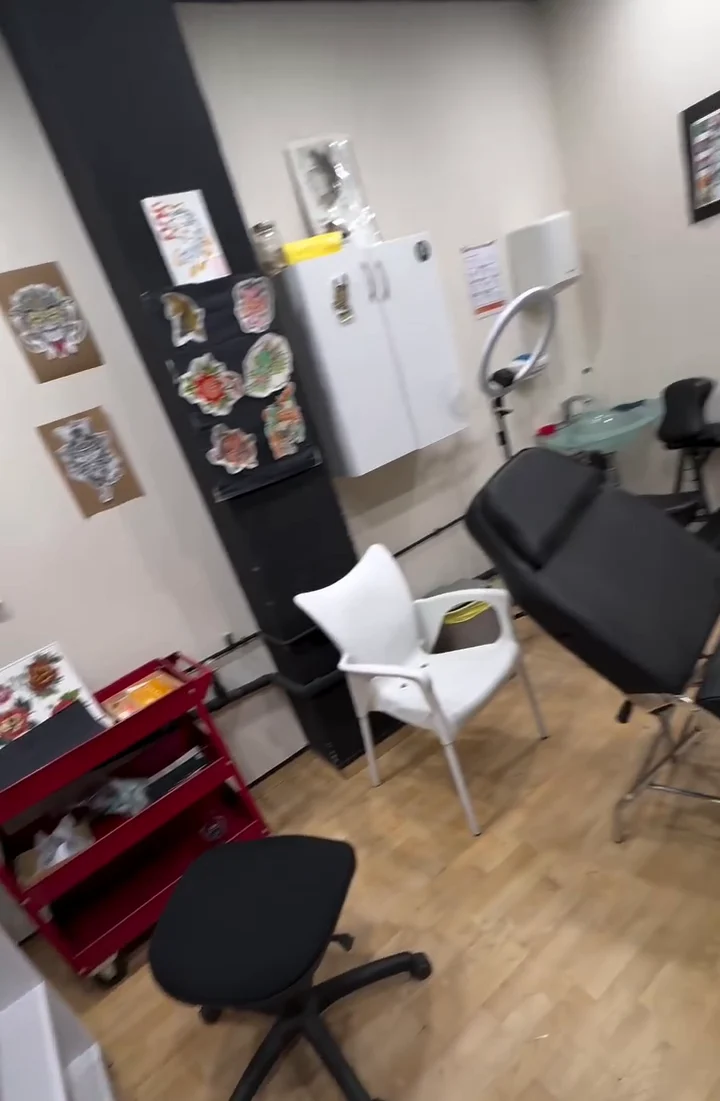 Sala de piercing del estudio, con carro de material y camilla